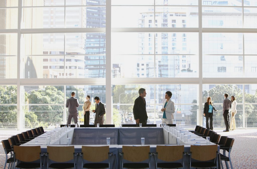 Group of people in meeting room with large window