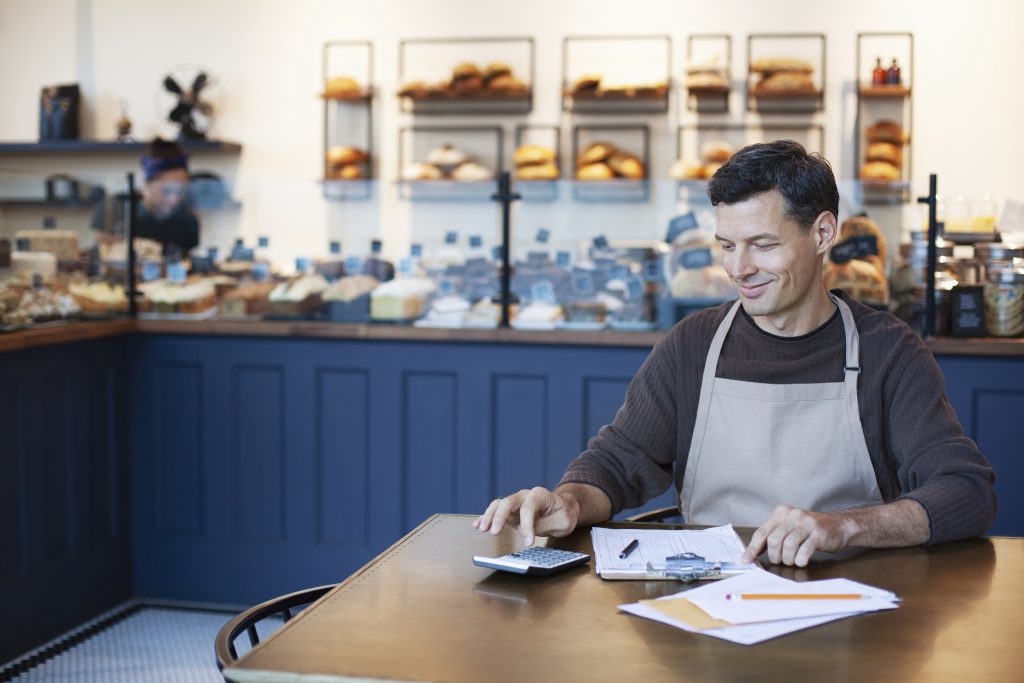 A self-employed business owner is comparing income protetcion quotes in his cafe