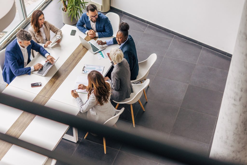 A group of professionals in a business meeting, representing planning and discussions around managing business debt and financial protection if an owner dies.