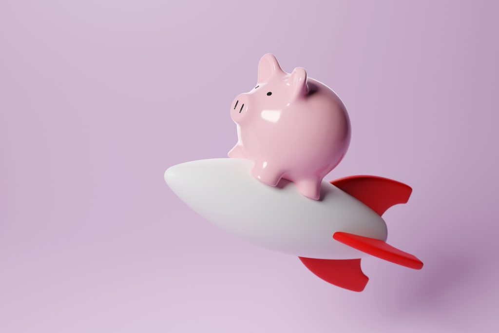 Pink piggy bank on a white toy rocket on pink background. Illustration of the concept of increased savings on life insurance