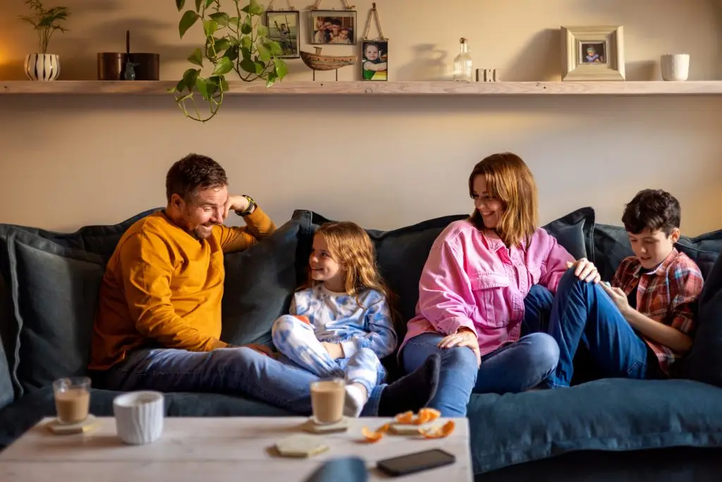 Happy parents with son and daughter relaxing on the couch