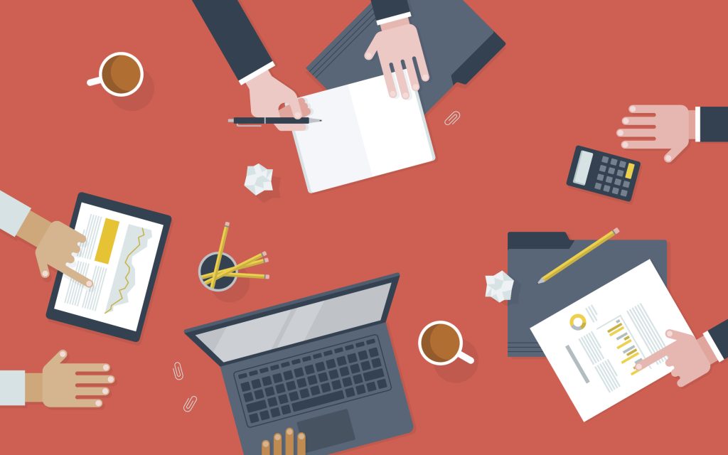 Image of a table with hands. A laptop and other financial documents.