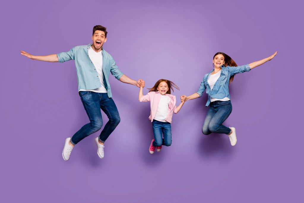 Full length photo of three, rejoicing jumping high family members wear casual clothes isolated purple background